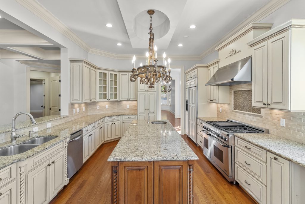 Kitchen with cream cabinetry, wood island and iron chandelier in a Raleigh, NC home