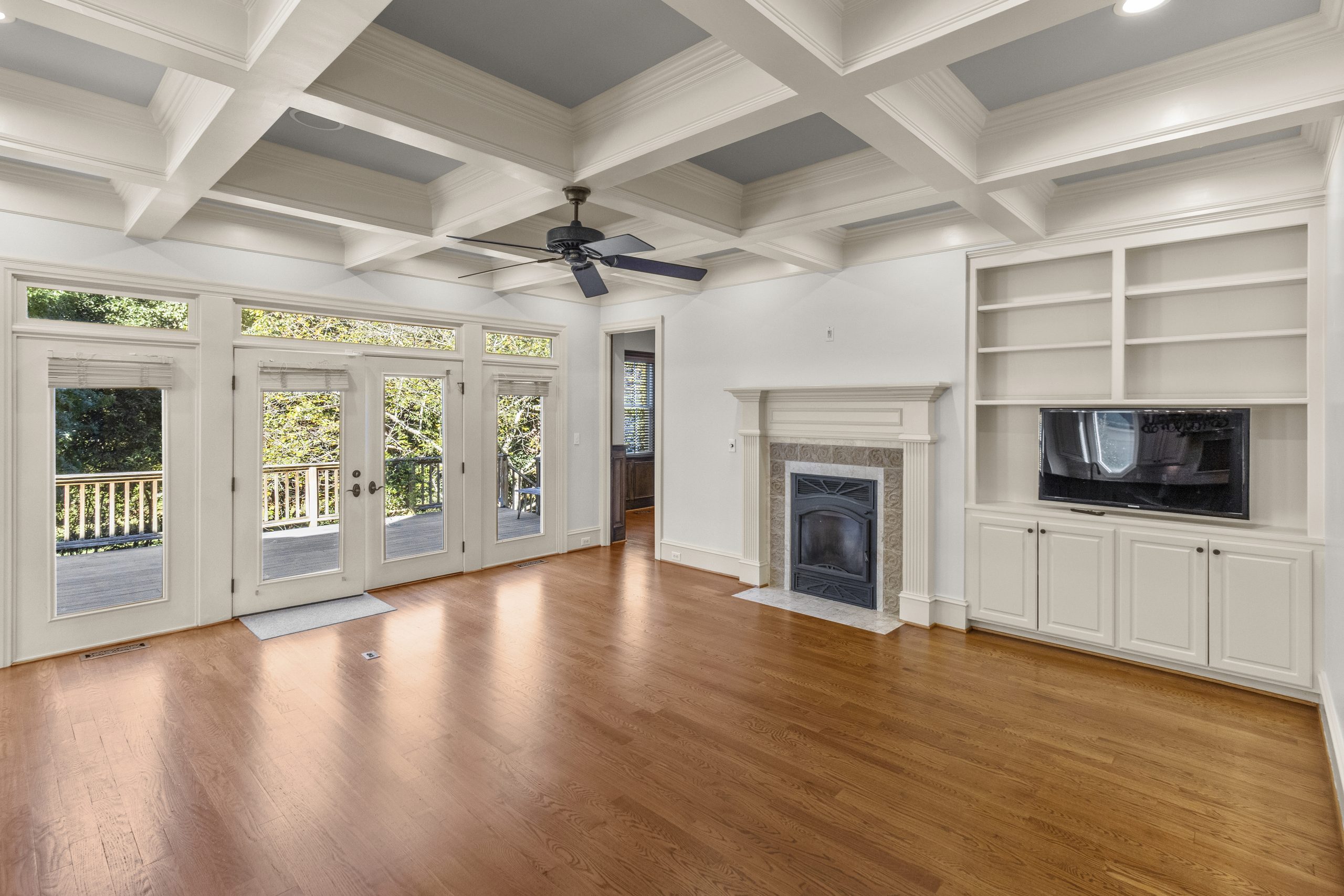 Family room with coffered ceiling and French doors to the deck in a Raleigh, NC home