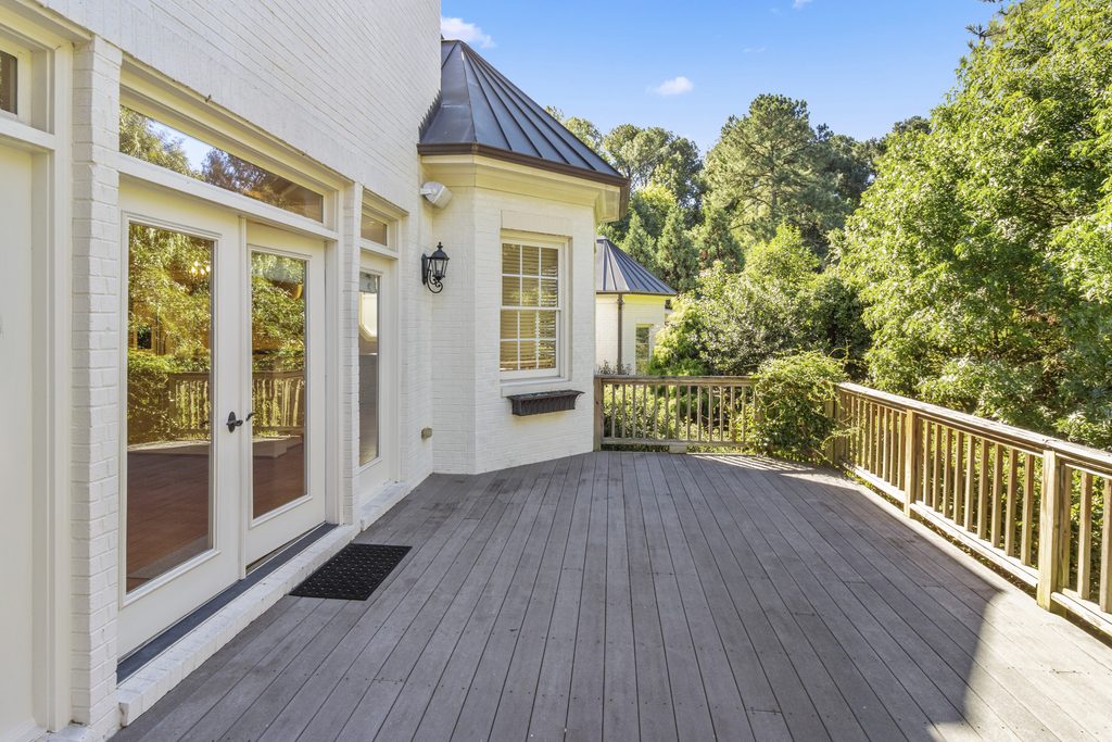 Ivory brick home with twin gables, round windows and an arched entry in West Raleigh, NC, photographed by Lightwell Haus