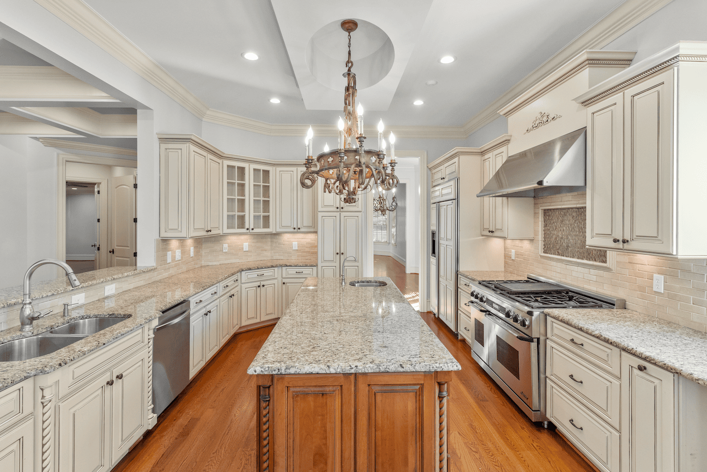 Onlooking into kitchen with elegant chandelier.